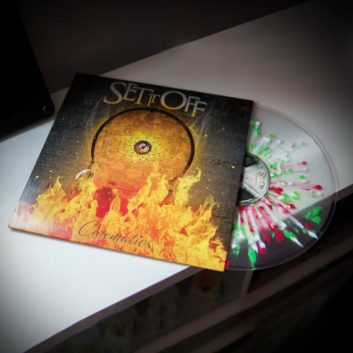 A limited edition (500 copies) Clear w/ Green & Red Splatter Vinyl of Set It Off’s Cinematics, partially out of its cover, displays a dreamcatcher and flames on the album’s striking front artwork.