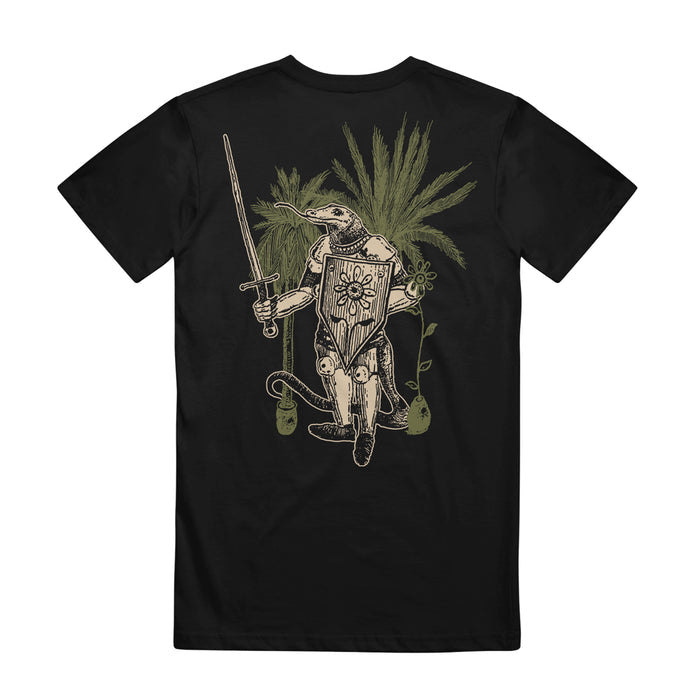The Resilia Knight Black T-shirt showcases a lizard in medieval armor wielding a sword, surrounded by leafy green plants and vines twisting around its legs.