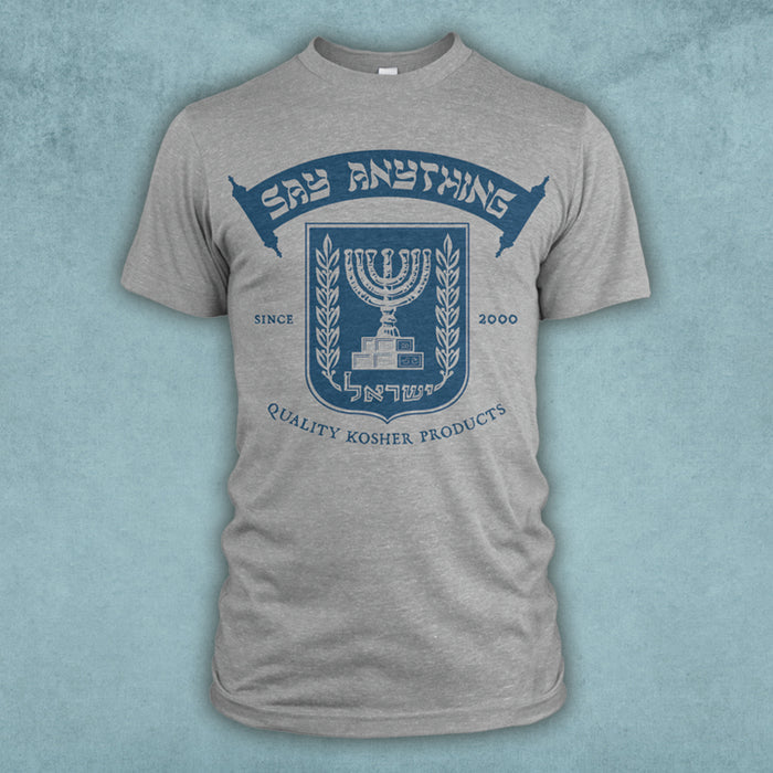 A grey t-shirt has a blue emblem of a menorah with the words "Say Anything" printed on a scroll above it. The words "Quality Kosher Products" are below it.