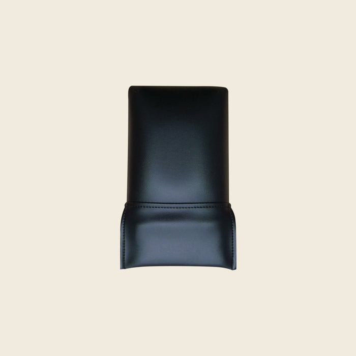 Black upholstered replacement head rest cushion for a Pilates Reformer, shown on beige.