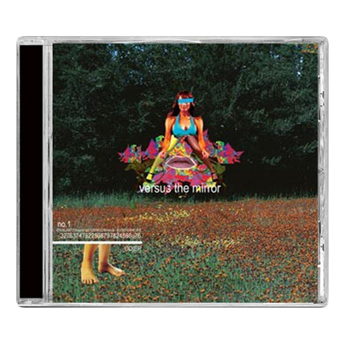 The Versus The Mirror CD cover features a blindfolded woman in colorful attire sitting cross-legged on grass, surrounded by surreal, artistic effects and floral elements, with versus the mirror displayed over the image.