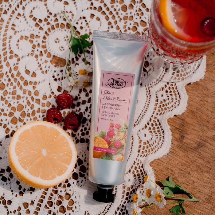 Hand cream tube with a glass of red beverage and lemon slice on a lace tablecloth