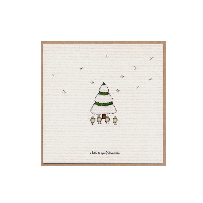 Christmas card with a small illustrated green tree and star dots on cream paper