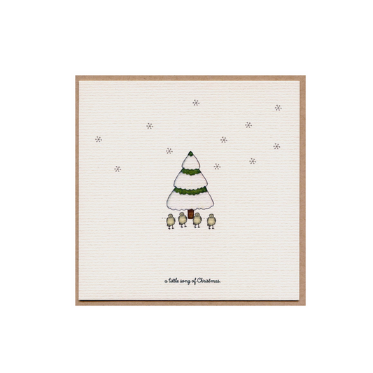 Christmas card with a small illustrated green tree and star dots on cream paper