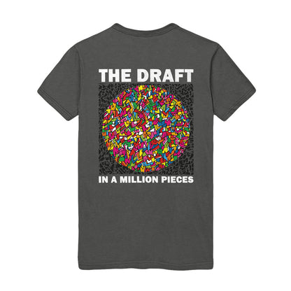 Photo of the front of the shirt, The shirt has a circular design. The Pattern is of colorful shards of stained glass.  The text "THE DRAFT" is on the top. The text on the bottom reads "IN A MILLION PIECES".