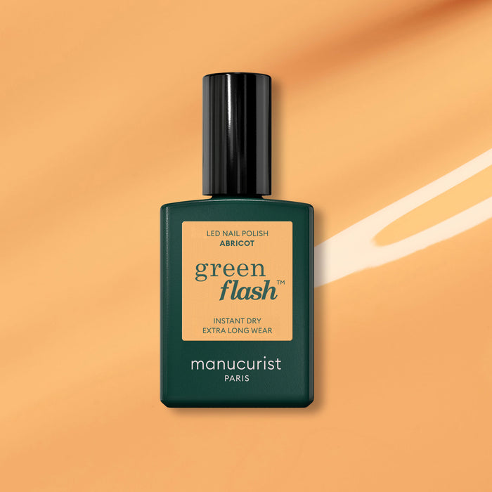 A bottle of Manucurist Abricot gel polish is shown against an orange background with a white brushstroke accent.