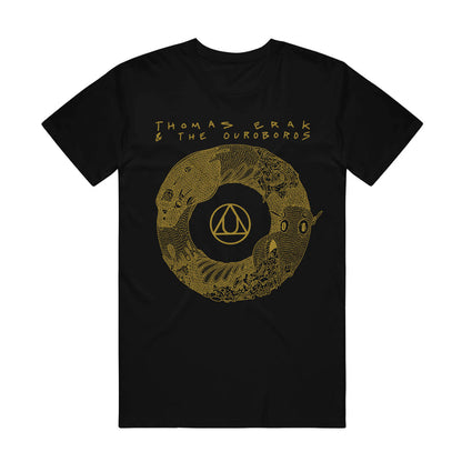 A black short sleeve t shirt has an image of a yellow ouroboros with the Au gold symbol in the center. At the top, yellow words say "Thomas Erak & The Ouroboros".