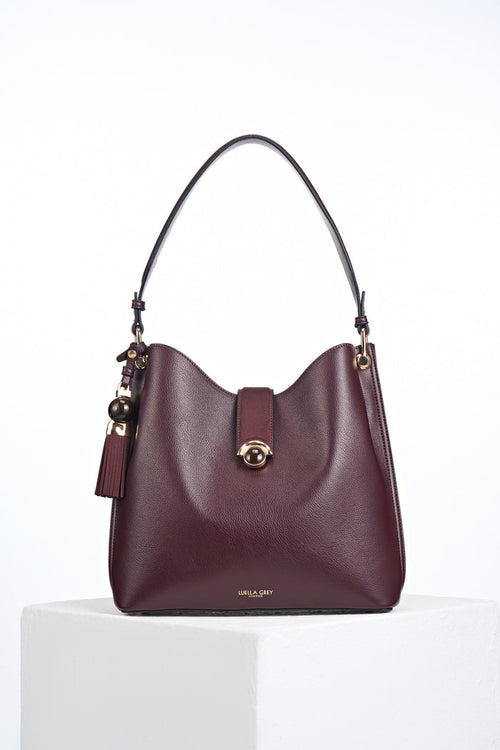 Front of the Andrea Black Cherry faux leather Hobo shoulder bag with Thames Tassel detail attached to the handle and a Crystal Palace clasp closure