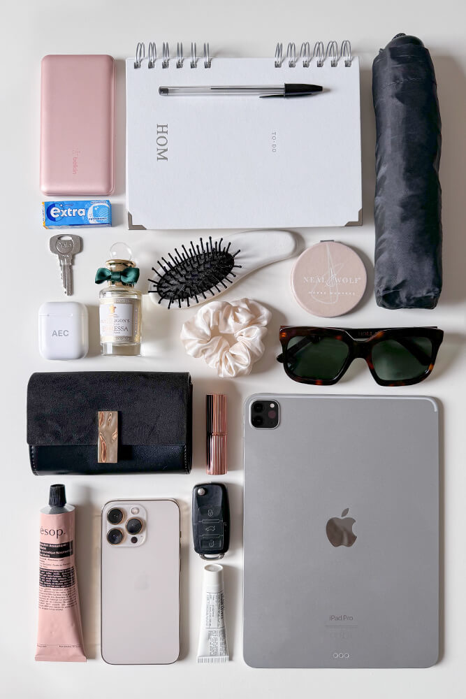 Collection of personal items including a purse, iPad, beauty products, and accessories to show what would fit in the Andrea Black Cherry faux leather Hobo shoulder bag