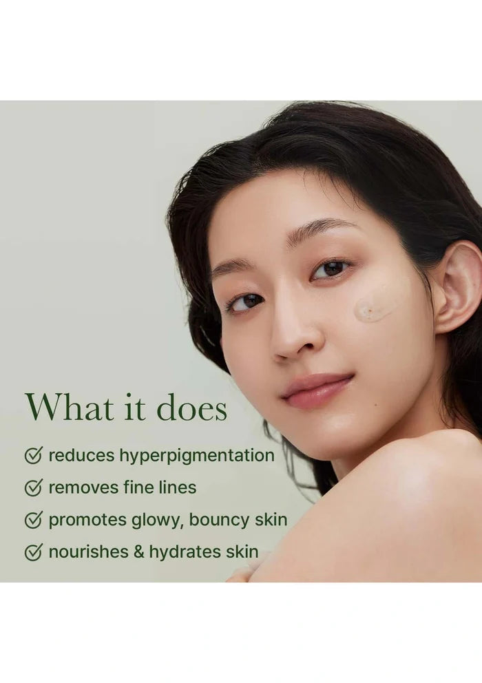 Woman with skin care product on face against a light gray background