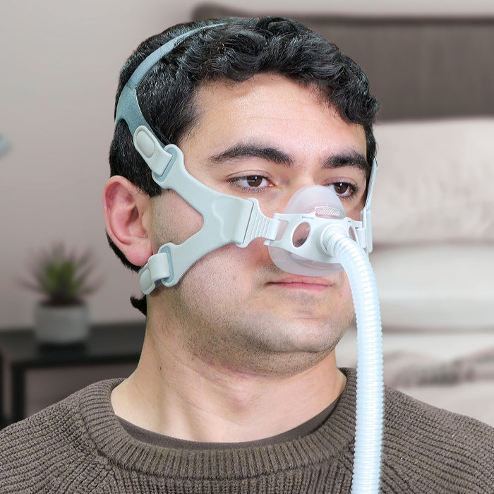 Man wearing a CPAP mask with a blurred indoor background