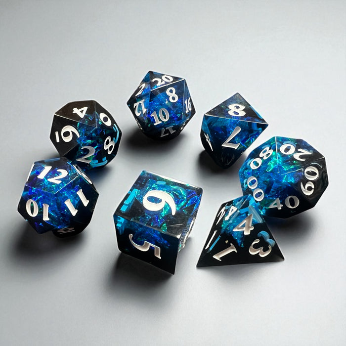 7-piece Black and Blue Prismatic RPG Dice Set with swirling resin and glitter, ideal for cosmic and dark fantasy campaigns.