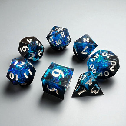 7-piece Black and Blue Prismatic RPG Dice Set with swirling resin and glitter, ideal for cosmic and dark fantasy campaigns.
