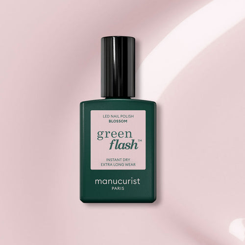 Manucurist Blossom: An opaque creamy gel polish in the shade Blossom, housed in a dark green rectangular bottle with a black cap and pale pink label, designed for chic nails.