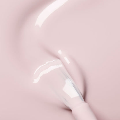 A close-up shows the Manucurist Blossom nail polish brush applying opaque, creamy light pink polish on a smooth surface with a glossy finish and soft lighting.