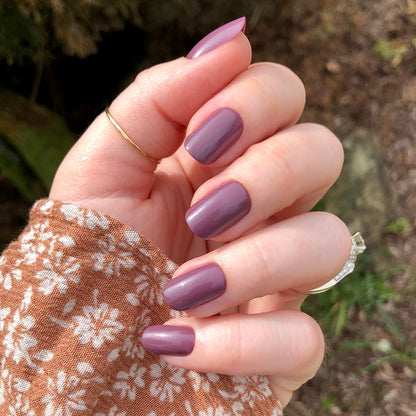 Cardigan | Short | Squoval - Tab Press-On nails in warm mauve shade with glossy finish on hand outdoors with floral sweater sleeve