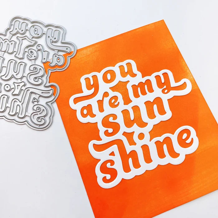 Catherine Pooler - Layered Word Dies - My Sunshine. This word die cuts a frame for the phrase "you are my sunshine" that can be used open or with the letters inlaid back inside for more color contrast. Available at Embellish Away located in Bowmanville Ontario Canada. Example by Catherine Pooler Designs.