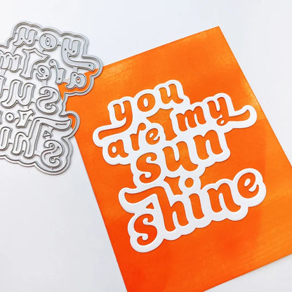 Catherine Pooler - Layered Word Dies - My Sunshine. This word die cuts a frame for the phrase "you are my sunshine" that can be used open or with the letters inlaid back inside for more color contrast. Available at Embellish Away located in Bowmanville Ontario Canada. Example by Catherine Pooler Designs.