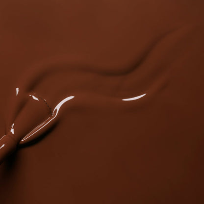 Close-up of smooth, melted chocolate with a glossy, swirling pattern—reminiscent of Manucurist's Chestnut gel polish.