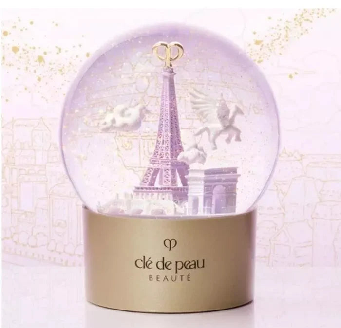 Clé de Peau Beauté Holiday Limited Edition Snow Globe featuring elegant design and festive scene, new in box.