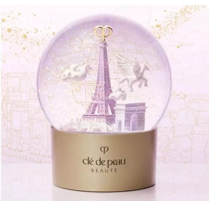 Clé de Peau Beauté Holiday Limited Edition Snow Globe featuring elegant design and festive scene, new in box.