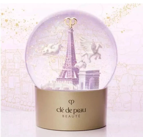 Clé de Peau Beauté Holiday Limited Edition Snow Globe featuring elegant design and festive scene, new in box.