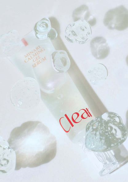 Skincare serum bottle with droplets on a light background