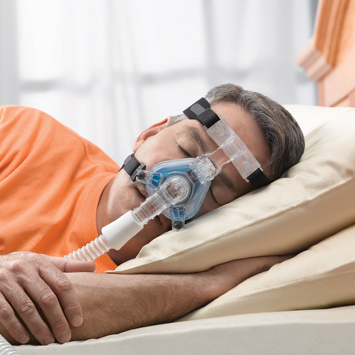 Man in bed sleeping with a Comfort Gel Blue CPAP Mask on
