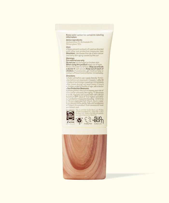 Back view of Sun Bum Daily 30 Glow sunscreen tube with text and wood-textured cap on white background.