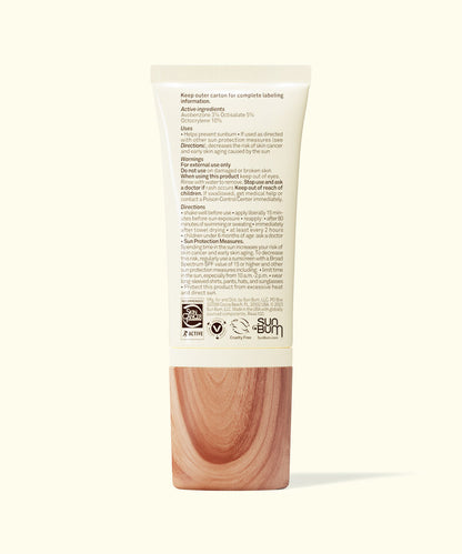 Back view of Sun Bum Daily 30 Glow sunscreen tube with text and wood-textured cap on white background.