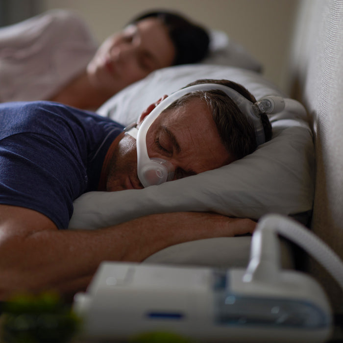 Man Wearing Dreanwisp Nasal CPAP Mask while in bed