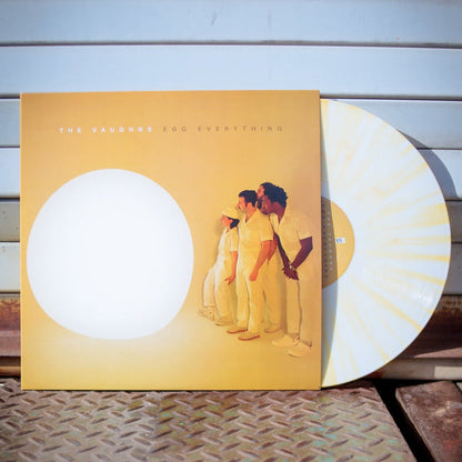 Album cover for The Vaughns' "VaughnsEgg Everything," showing four people in white before a bright white circle, with a yellow-and-white Egg Shell W/ Yolk Splatter limited edition vinyl from The Vaughns partially visible.
