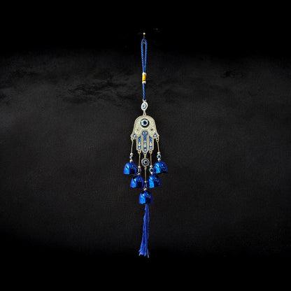 Brass Evil Eye Wind Chimes with five bells and Hand of Hamsa design, measuring 17 inches in length, hanging against a neutral background.