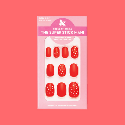 Festive Stars | Extra Short | Round - Tab Press-On nails in bright red with small white star accents in retail packaging