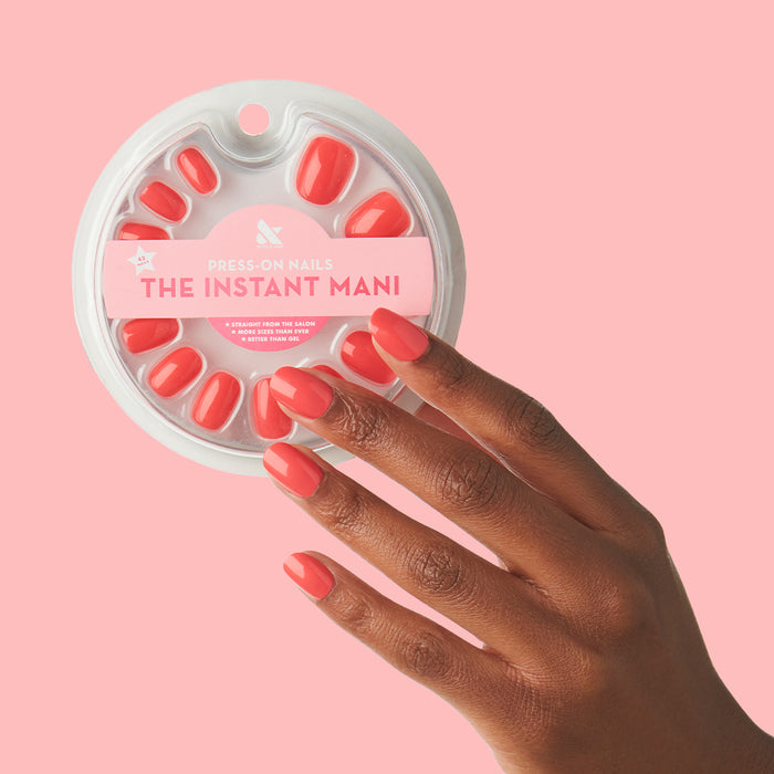 Hand with Field Day | Round | Extra Short press-on nails in juicy watermelon red matte finish on dark skin tone against pink background