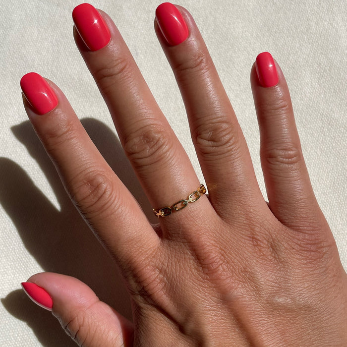 Hand with Field Day | Round | Extra Short press-on nails in vibrant watermelon red on natural skin tone against textured light background