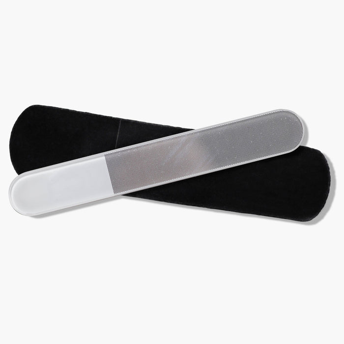 The Glass Nail Buffer by LONDONTOWN, featuring a frosted handle and textured surface, rests on a black pouch, ready to polish your nails to a smooth shine.