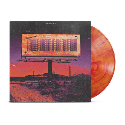 Shallow Pools I Think About It All The Time Vinyl LP. album art depicts a billboard on the side of the road in the desert with the title of the album on the billboard repeating a few times. the vinyl color is yellow and orange marble.