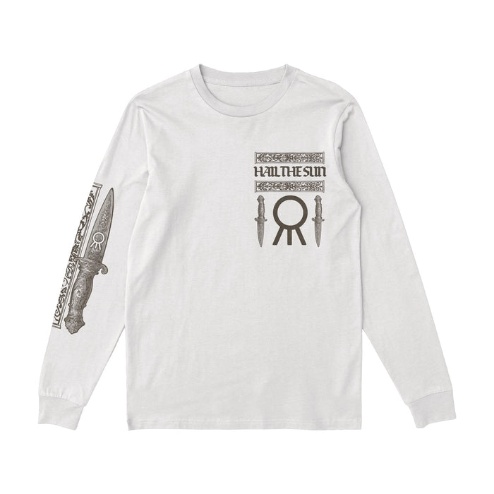 A white long-sleeve Hail The Sun shirt with the bands name and two knife graphics on the chest, a large circular symbol below, and a detailed dagger design on the right sleeve.