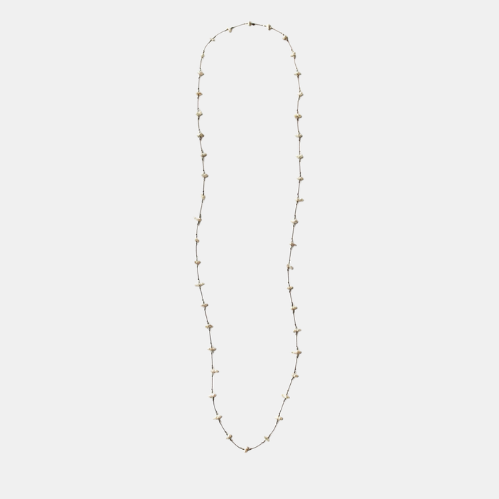 Long keshi pearl necklace with small white teardrop pearls on a thin gold-tone chain