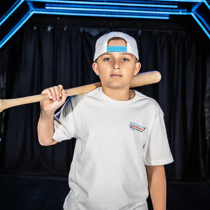 Youth model wearing white youth graphic tee with "Miami Marlins Drip" design