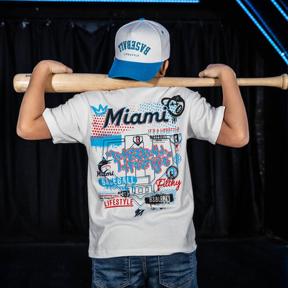 Youth model wearing white youth graphic tee with "Miami Marlins Drip" design