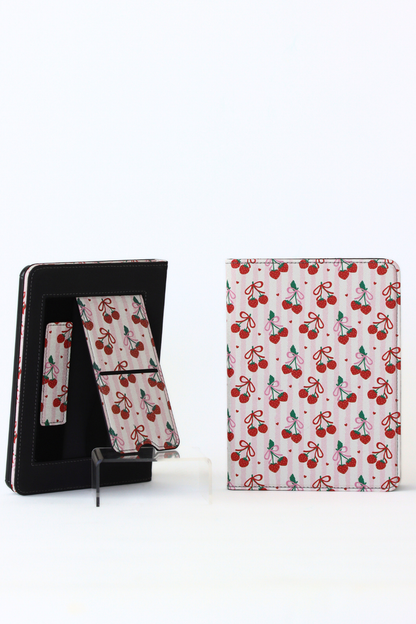Cherry-patterned kindle case with stand feature on a white background