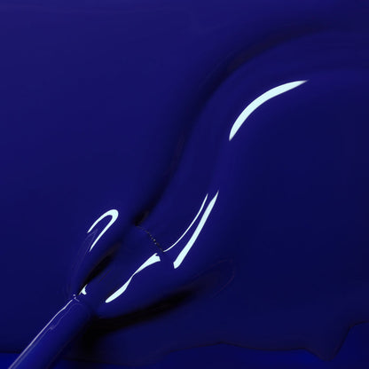 Close-up of a brush applying Manucurist's Navy Blue gel polish, showcasing its smooth, shiny texture and curved highlights that reflect light on the glossy surface.