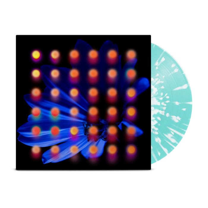 Light teal splattered vinyl peeks out of a black jacket with a dark blue flower background. There are orange and pink dots layered over the image of the flower.