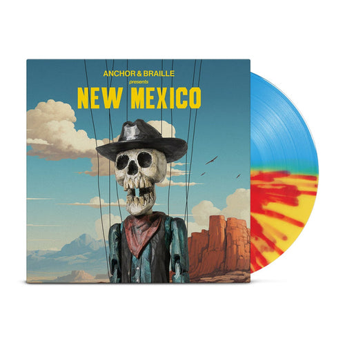 A half blue/half yellow/half orange splatter vinyl peeks out of a mainly blue jacket with an image of the desert with a blue sky with clouds. In front of the background is a skeleton dressed as a western cowboy with strings holding him up. The yellow text on the jacket reads "Anchor&Braille presents New Mexico".