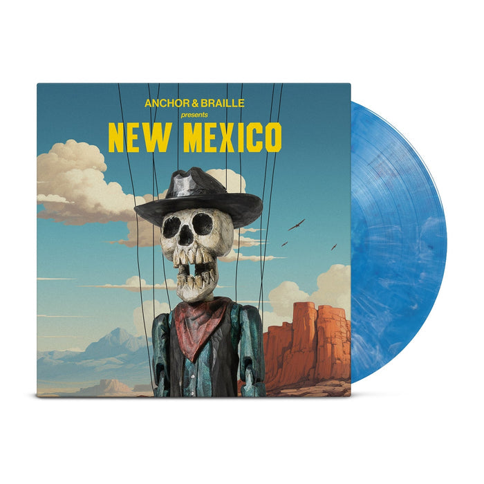 An opaque blue vinyl peeks out of a mainly blue jacket with an image of the desert with a blue sky with clouds. In front of the background is a skeleton dressed as a western cowboy with strings holding him up. The yellow text on the jacket reads "Anchor&Braille presents New Mexico".