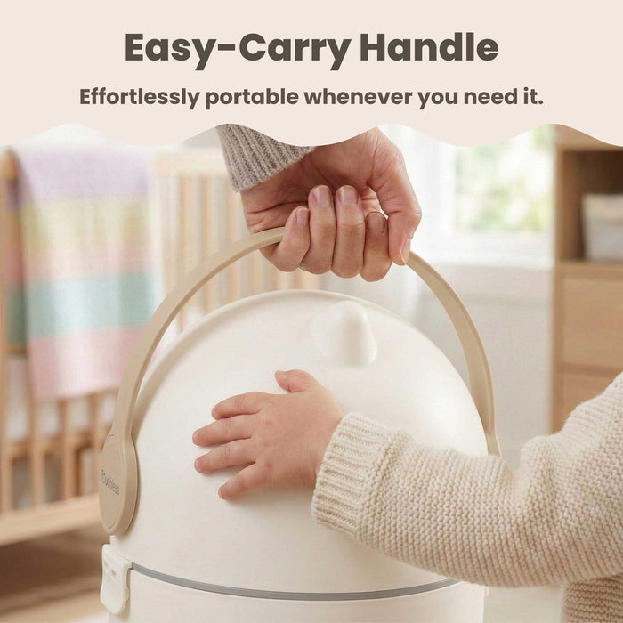 Close-up of a person using the easy-carry handle to lift the iTouchless Odorless Diaper Pail in Boho Ivory. A baby's hand is visible touching the pail in a nursery setting, emphasizing the product's effortless portability and child-friendly design.