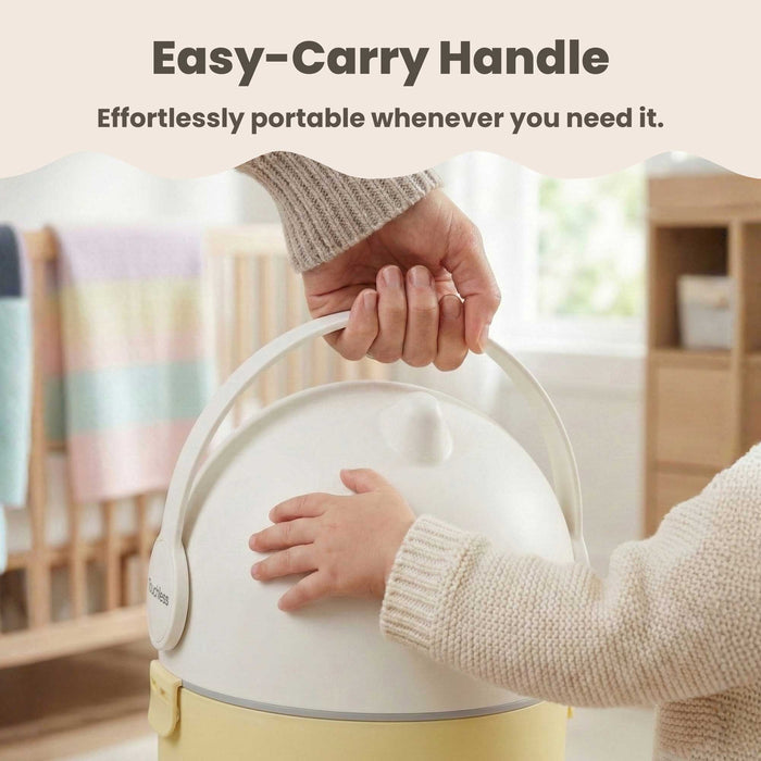 Close-up of a person using the easy-carry handle to lift the iTouchless Odorless Diaper Pail in Sand Almond. A baby's hand is visible touching the pail in a nursery setting, emphasizing the product's effortless portability and child-friendly design.