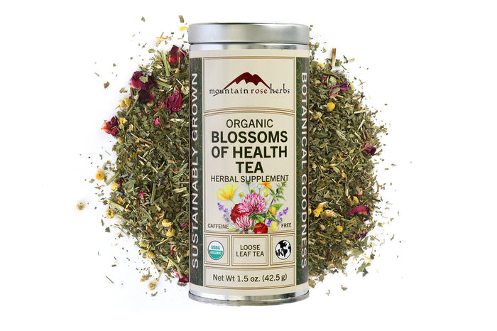 Mountain Rose Herbs Organic Blossoms of Health Tea canister with tea leaves and flowers on a white background, Raven's Cauldron, 6 N. Sandusky St, Delaware, OH 43015